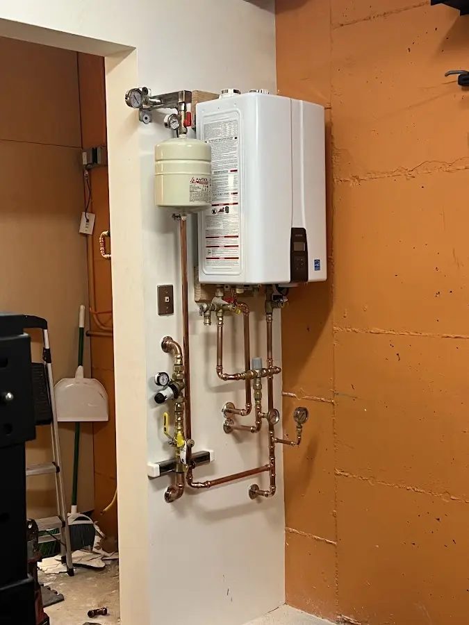 Plumbing technician inspecting water heater connections in Palm Beach